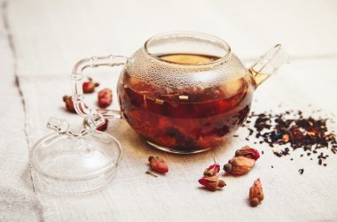 Kuru kırmızı küçük gül cam çaydanlık, çay içiyor, tablo kaba keten Tableclose içinde; Tonda