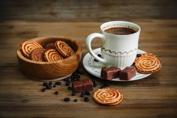 There are Cookies,Candy,Chocolate Peas,Poppy;Porcelain Saucer and Cap with Coffe,Tasty Sweet Food on the Wooden Background,Toned — Stock Photo, Image