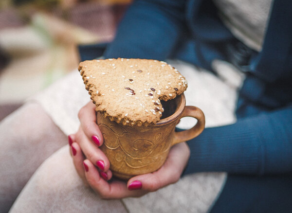 Two Heart Form Cookie is on the Clay Cup in the Women 's Hands.Selective Focus
