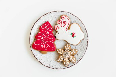 Yeni yıl ve Noel kompozisyonu. Tabakta zencefilli kurabiye var. geyik ve ağaç şeklinde. beyaz arkaplan