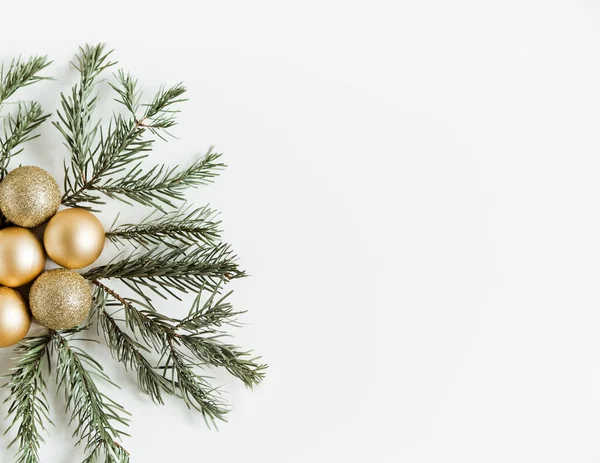 圣诞公寓位于白色的背景上 松树枝条和金色的圣诞球 简约主义风格 复制空间 — 图库照片