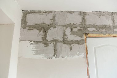 Tadilat sırasında duvar. Alçıyla kaplanmış köpük bloğu. Alçı duvarlar..