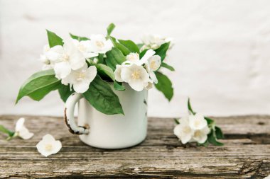 Yasemin çiçekleri kırsal metal bardakta. eski rustik ahşap arkaplan