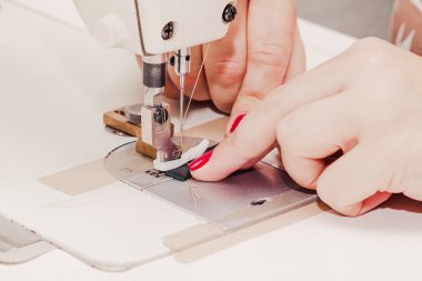 bir dikiş makinesi üzerinde çalışan el terzi