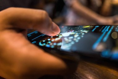 Sosyal medyada fotoğraf çeken, akıllı telefon uygulamasında kalp ikonunu parmaklarıyla iten bir adam. Arkadaş, takipçi, hayran fotoğrafı. Online randevu, sosyal ağ konsepti. Seçici odak.