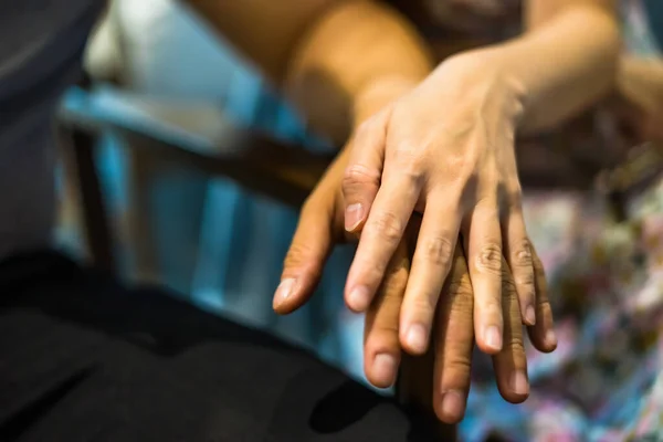 Closeup on two young lovers holding hands at a table, symbol sign sincere feelings, compassion, loved one, say sorry. Reliable person, trusted friend, true friendship concept. Selective focus.