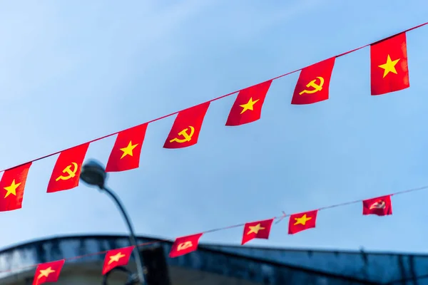 Vietnamese red with yellow star flag and Communist Party of Vietnam flag. Waving colorful national Vietnamese flag in blue sky. Politics and tourism concept