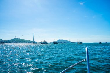 Phu Quoc, Vietnam, Asya 'daki Hon Thom adası - renkli evler, mavi dalgalar ve mavi gökyüzü ile tropikal manzara, balıkçı tekneleri ve çok uzaktaki en uzun teleferik. Seyahat kavramı.