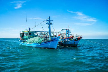 Phu Quoc, Vietnam, Asya 'daki Hon Thom adası - renkli evler, mavi dalgalar ve mavi gökyüzü ile tropikal manzara, balıkçı tekneleri ve çok uzaktaki en uzun teleferik. Seyahat kavramı.