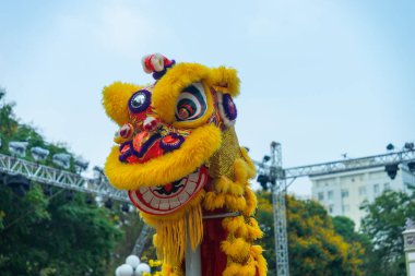 Aslan dansı - ejderha ve aslan sokak gösterileri. Arka planda mavi gökyüzü olan sarı aslan başı. Kültür ve festival konsepti.