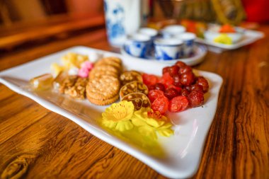 Bahar tatilinde Vietnam yemeklerini görmek, reçel yeni yılda geleneksel yemek ve çaydanlıktır. Geleneksel tatlı olarak kurutulmuş meyve ve reçel, ahşap masada Mut Tet. Seçici odak.