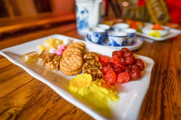 View of Vietnamese food for Tet holiday in spring, jam is traditional food and teapot set on lunar new year. Dried fruit and jam as tradition dessert - Mut Tet on wooden table. Selective focus.