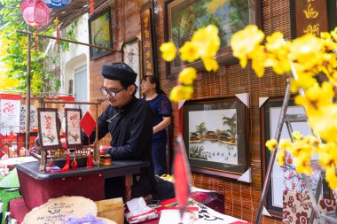 Ho Chi Minh şehri, Vietnam - 28 Ocak 2021: Vietnamlı bilginler ay yeni yılında kaligrafi yazıyor. Kaligrafi festivali Tet tatili sırasında popüler bir gelenektir.