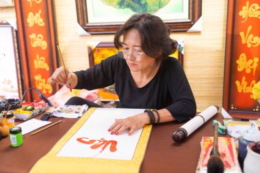 Ho Chi Minh şehri, Vietnam - 28 Ocak 2021: Vietnamlı bilginler ay yeni yılında kaligrafi yazıyor. Kaligrafi festivali Tet tatili sırasında popüler bir gelenektir.