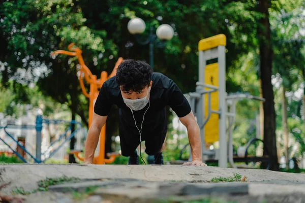 亚洲人戴着防空洞的面具 在公园里为健康做俯卧撑 社会疏离 锻炼和新的正常观念 — 图库照片
