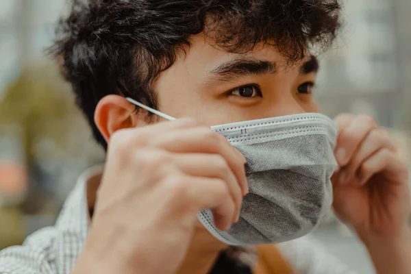 close up face of young asian man wearing medical mask. Selective focus.