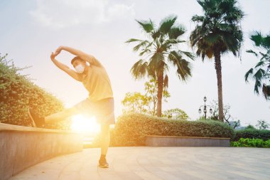 Sosyal uzaklık. Korumalı maskeli genç Asyalı adam dışarıda parkta çalışıyor. Egzersiz yap. Karantinada spor. Covid-19. Korunma. Seçici odak.