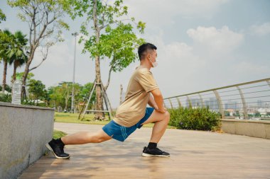 Sosyal uzaklık. Korumalı maskeli genç Asyalı adam dışarıda parkta çalışıyor. Egzersiz yap. Karantinada spor. Covid-19. Korunma. Seçici odak.