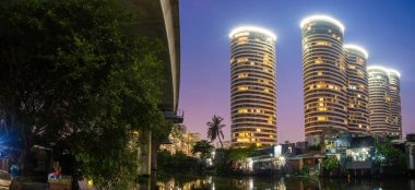 Vietnam gibi gelişmekte olan ülkelerdeki yeni modern binalar ve gecekondular arasındaki zıtlık sahnesi. Manzara Ho Chi Minh şehrinde zengin ve fakir arasındaki bir yansımayı temsil eder..