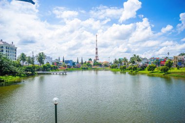 Bao Loc şehri, Vietnam - 01 Mayıs 2021: Küçük Dong Nai Gölü manzarası - Bao Loc şehrinin merkezi gölü, Lam Dong eyaleti, Vietnam. Büyük bir televizyon kulesinin yanında güzel duruyor..