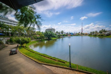 Bao Loc şehri, Vietnam - 01 Mayıs 2021: Küçük Dong Nai Gölü manzarası - Bao Loc şehrinin merkezi gölü, Lam Dong eyaleti, Vietnam. Büyük bir televizyon kulesinin yanında güzel duruyor..