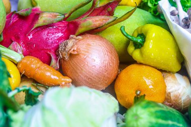 Close-up of fresh vegetables in cardboard box on the table delivered to home, donation box with supplies food for people, vegetables and fruit in cardboard box. Selective focus.