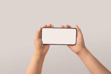 Beyaz ekran ekranı, akıllı telefon, akıllı telefon ve model konsepti olan beyaz arka planda izole edilmiş beyaz bir telefonu tutan kadın. Seçici odak