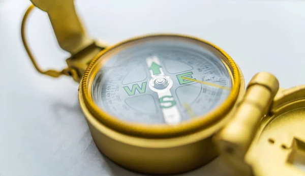 Banner of golden compass isolated, shallow DOF, focus on dial. Compass on a white background. Concept for direction, travel, guidance or assistance. Selective focus.