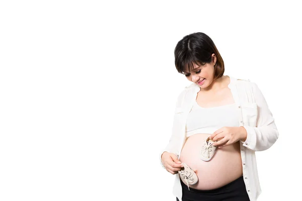 Zapatos pequeños para el feto en el vientre de las mujeres embarazadas — Foto de Stock