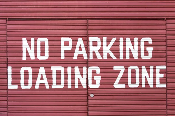 Word of No parking loading zone on metal red door — Stock Photo, Image