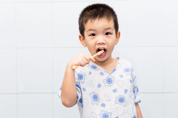 Piccolo bello asiatico ragazzo spazzolatura denti in bagno Immagini Stock Royalty Free
