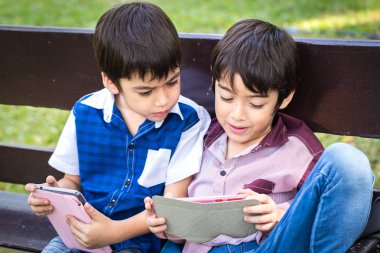 Küçük yakışıklı çocuk iPad tablet üzerinde seyir ve p oyun oynama