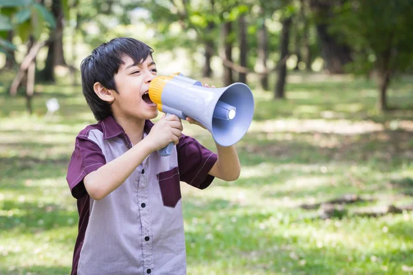 Little boy hold and shouting through megaphone in park — Stock Photo, Image