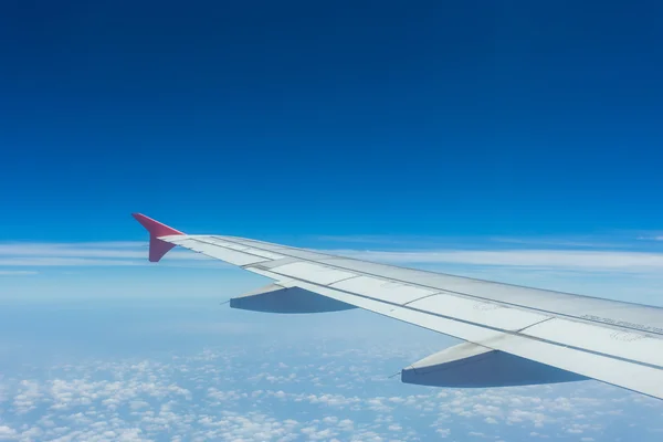 Nubes y cielo visto a través de la ventana de un avión — Foto de Stock