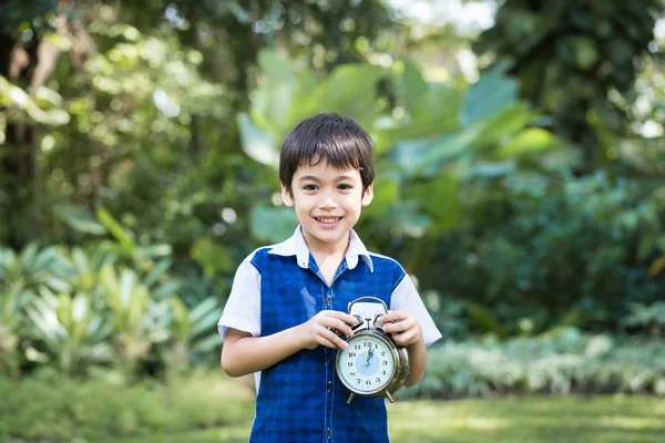 Asian little boy hold a clock and smile in park — Stock Photo, Image