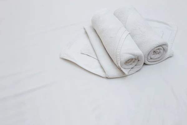 Close up of nice white towels on white bed sheet — Stock Photo, Image