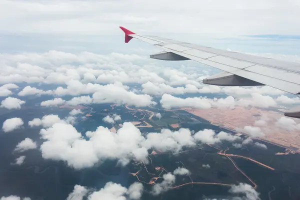 Bulutlar ve bir uçak pencereden görüldüğü gibi mısır tarlası — Stok fotoğraf