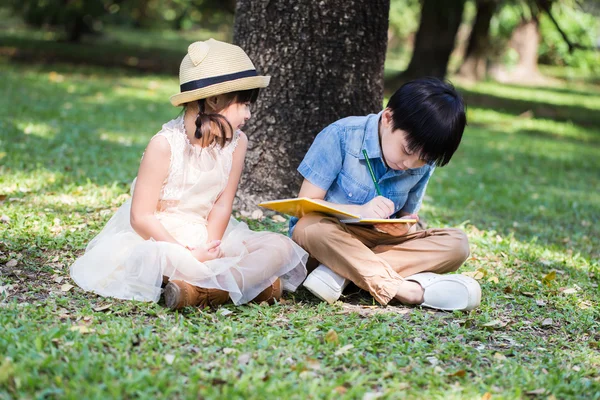 Little asian boy use pencil writting on notebook for writing boo — Stock Photo, Image