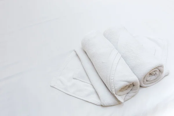 Close up of nice white towels on white bed sheet — Stock Photo, Image