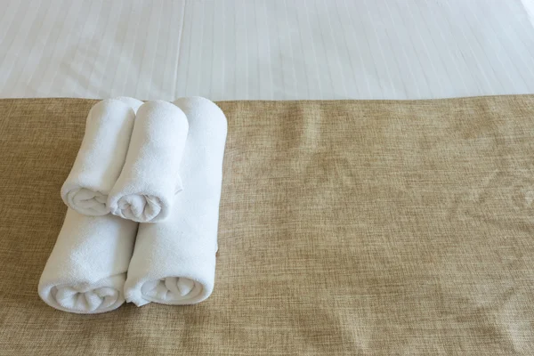 Close up of nice towels on white bed sheet with yellow ribbon — Stock Photo, Image