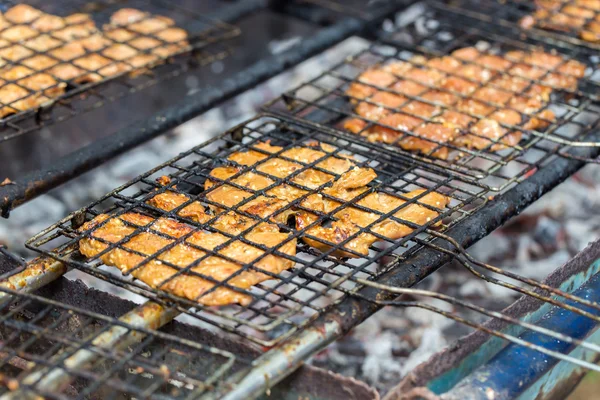 Pork chops getting grilled on grill with flames. — Stock Photo, Image