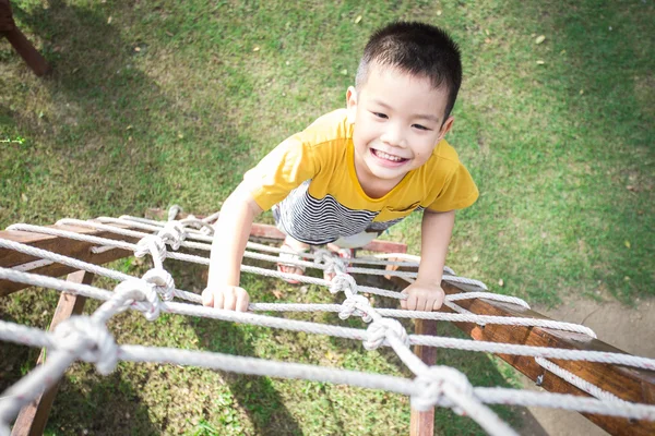 Poco asiático chico escalada cuerda obstáculo actividad en el playgrou — Foto de Stock