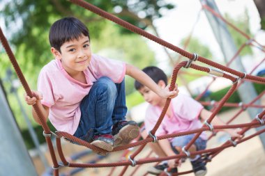 Küçük Asyalı çocuk ip engel aktivite üzerinde playgrou tırmanma