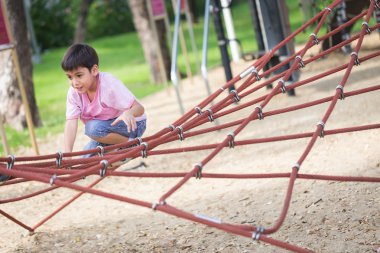 Küçük Asyalı çocuk ip engel aktivite üzerinde playgrou tırmanma
