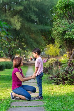 Park holding boyuyla oturan ve oğlu öğretim anne