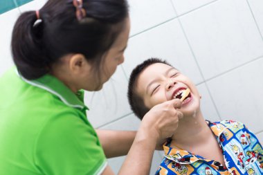 Fırçalama diş yüzü gülen ile banyo Asya çocukta anne