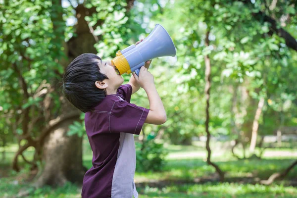 Little boy hold and shouting through megaphone in park — Stock Photo, Image