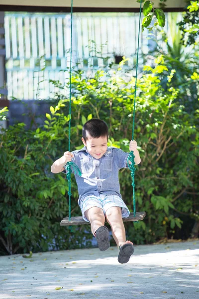Asiático bebé niño jugando en un swing — Foto de Stock