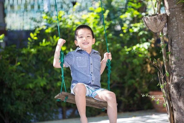 Asiático bebé niño jugando en un swing y divertirse en parque — Foto de Stock