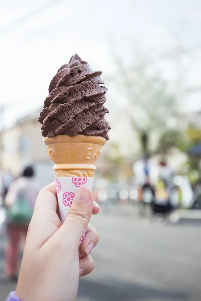 Ženy ruka drží kužel s mandlí čokoládová zmrzlina — Stock fotografie